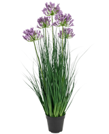 Der Kunstrasen-Agapanthus-Zwiebelgrastopf in Lila ist eine 90 cm hohe, feuerhemmende Kunstpflanze mit langen grünen Blättern und violetten Blütensträußen, die in einem schlichten schwarzen Topf vor einem weißen Hintergrund präsentiert wird.