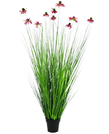 De Kunst Grasplant Chrysant 150 cm brandvertragend heeft lange, dunne groene grasachtige bladeren en lange stelen met roze margrietachtige bloemen, gepresenteerd in een pot tegen een effen witte achtergrond.